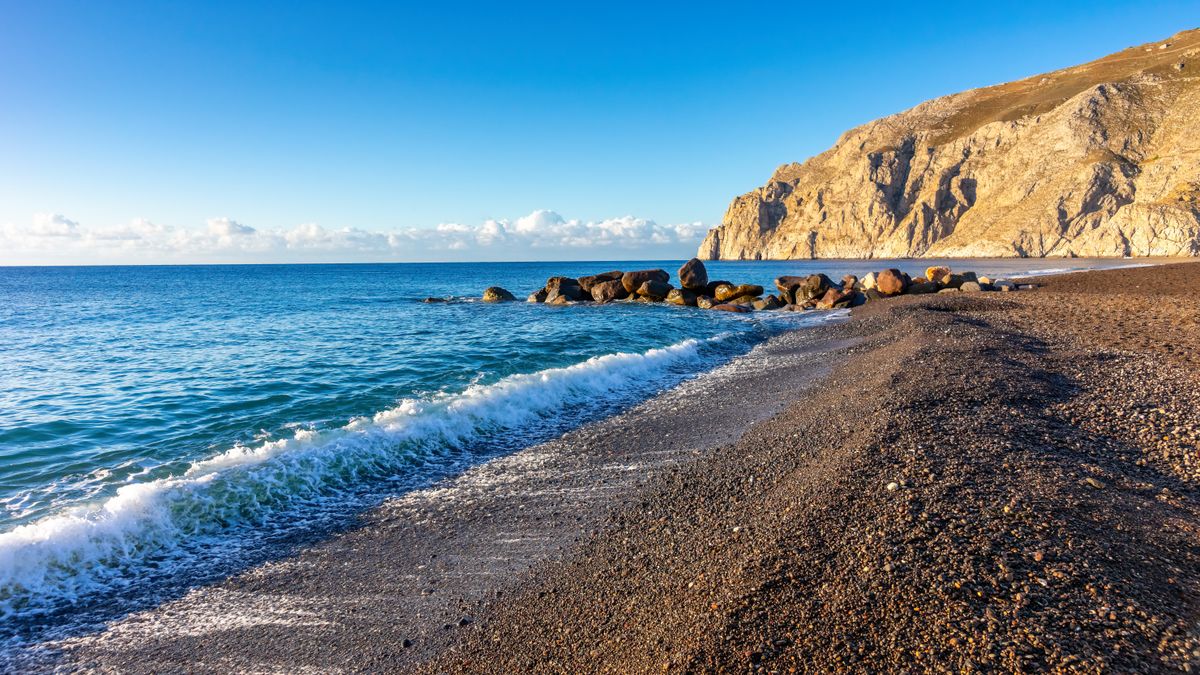 Dark volcanic beach with cliffs