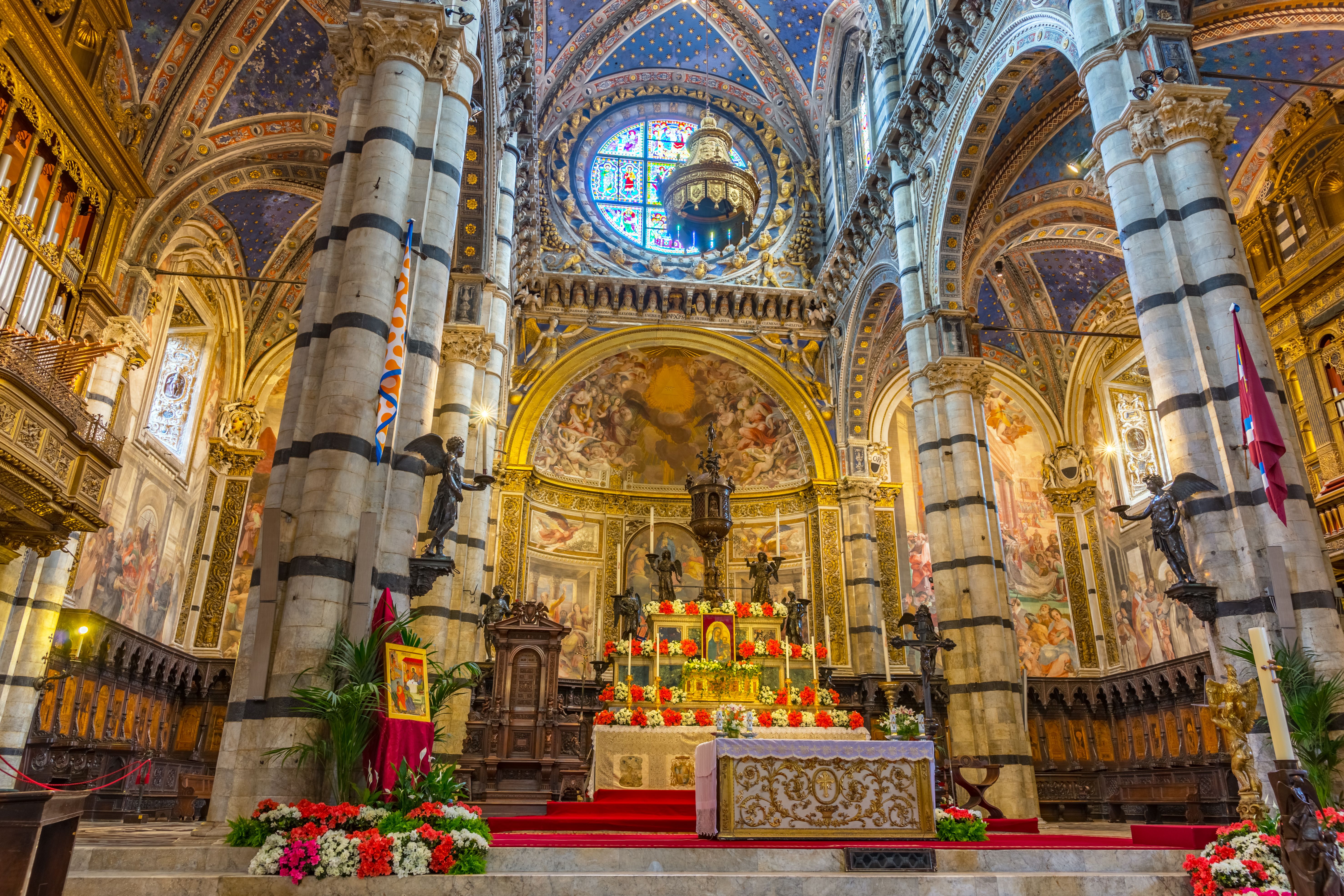 Stunningly ornate interior of the iconic Siena Cathedral showcasing intricate frescoes and architecture.