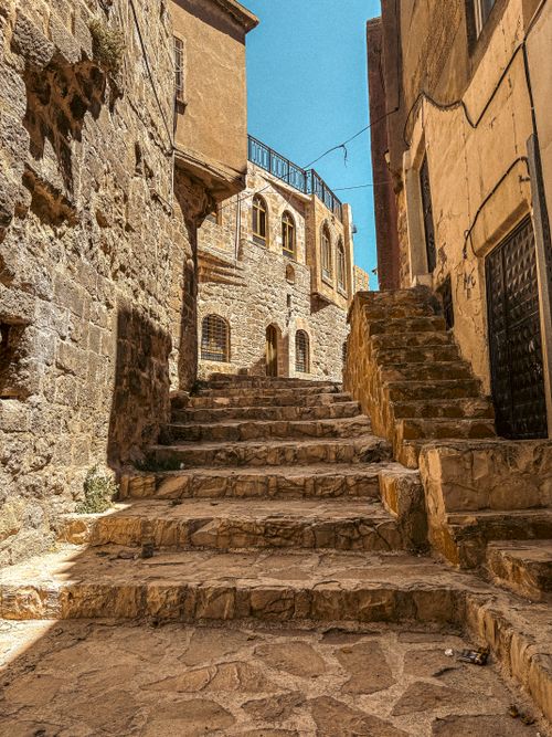 Free Rustic stone steps in a historic alleyway on a sunny day, showcasing architectural charm. Stock Photo