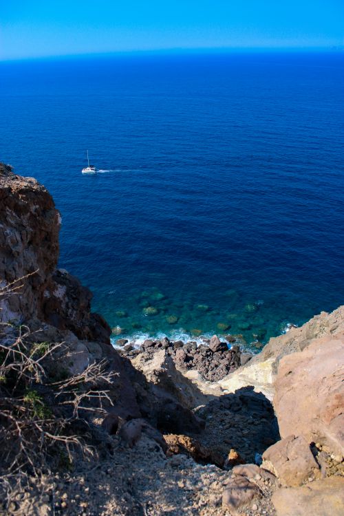 Free Explore the captivating cliffs and azure waters of Santorini, capturing Greece's natural beauty. Stock Photo