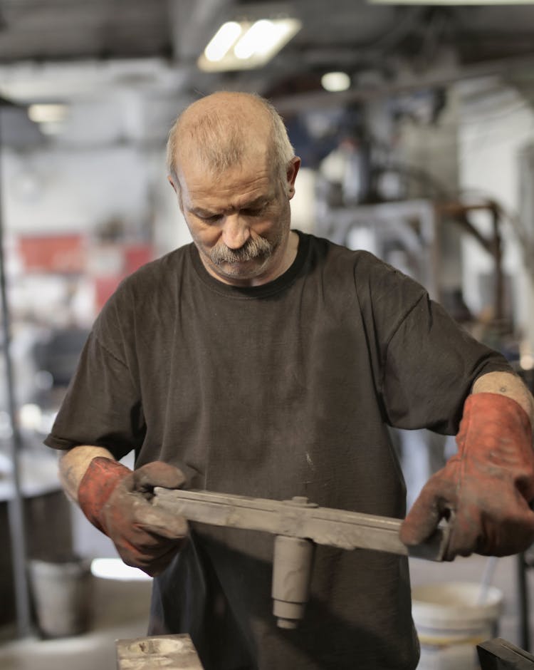 Focused Senior Fitter Assembling Detail In Workshop