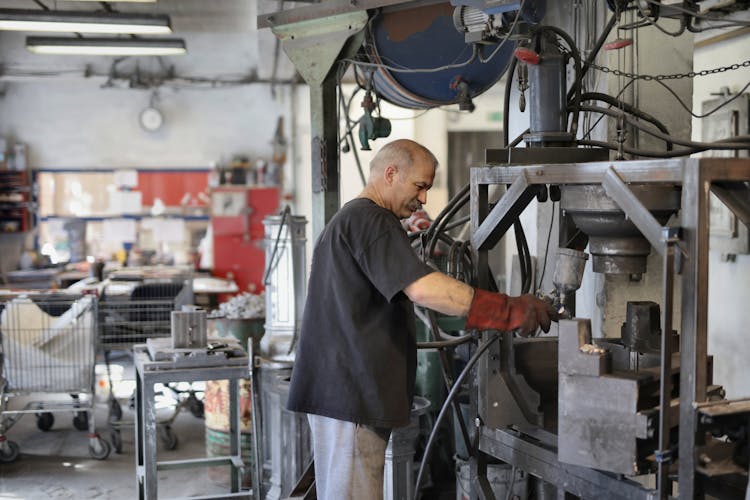 Elderly White Hair Worker Using Machine