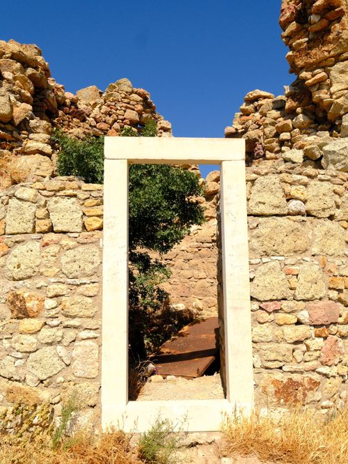 Free Stone ruins with a doorway leading to a sunny path, in İzmir, Türkiye. Stock Photo