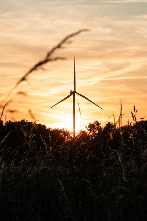 Free Silhouetted wind turbine against a vibrant sunset sky over fields in Gescher, Germany. Stock Photo