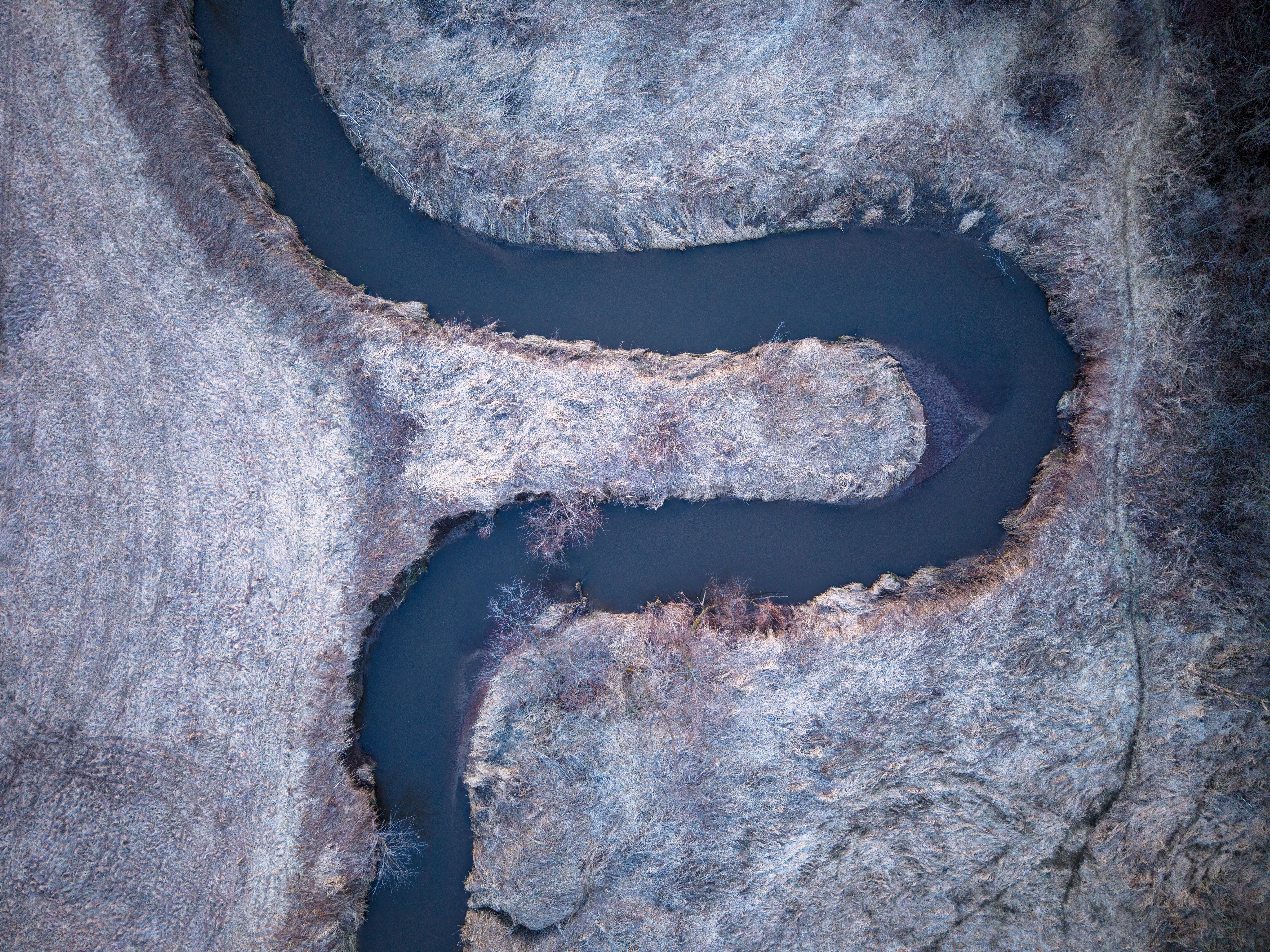 Drone view of a winding river through frosty landscapes in Wisconsin.