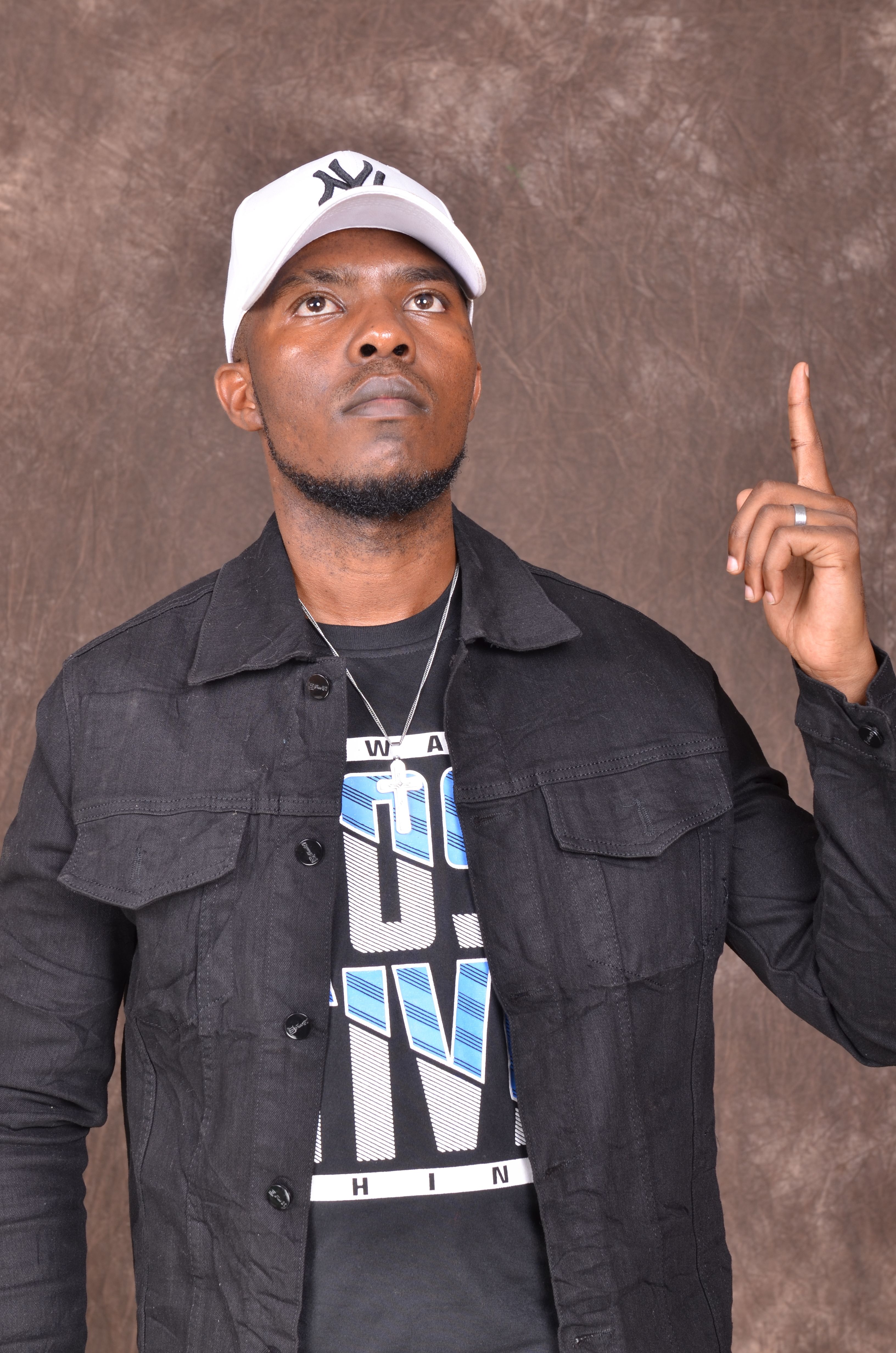 Portrait of an African man wearing a hat, pointing upwards, representing confidence and self-assurance.