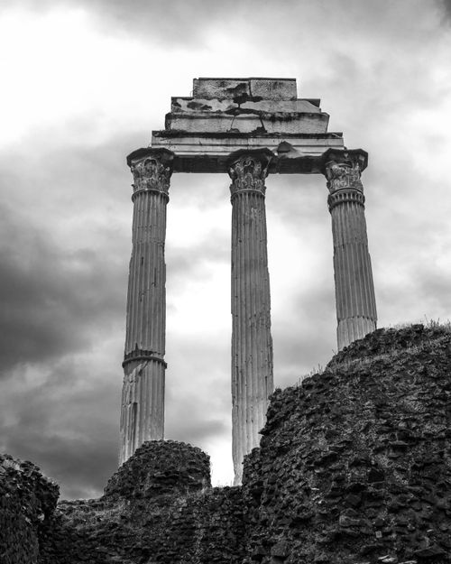 Free Dramatic black and white photo of ancient Roman temple columns in Rome's historical area. Stock Photo