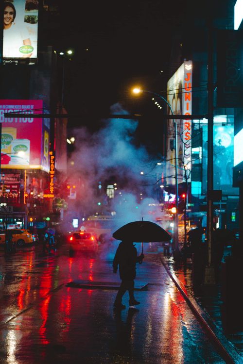 Free Mysterious silhouette with umbrella on a rainy city street night. Stock Photo