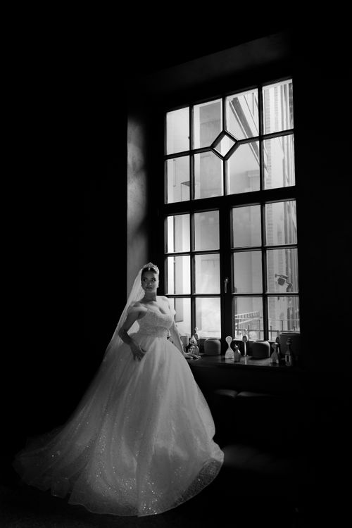 Free A stunning black and white bridal portrait capturing elegance and grace by a window. Stock Photo
