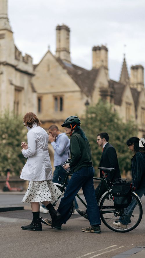 Free Group of people passing by historic architecture on a street. Stock Photo