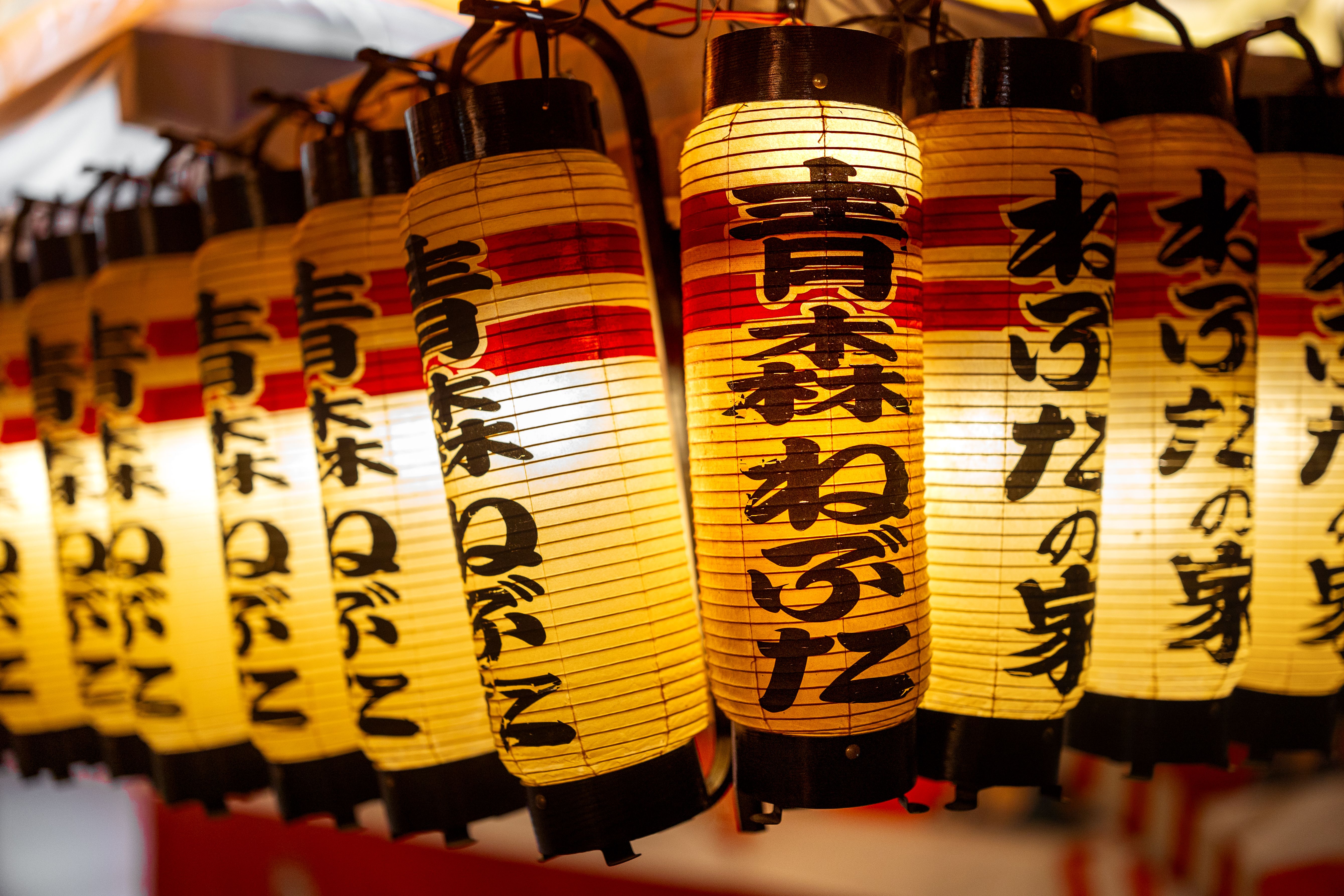 青森県で開催されたねぶた祭りで、灯りのともった紙提灯をクローズアップした写真。日本の文化芸術を象徴する作品。