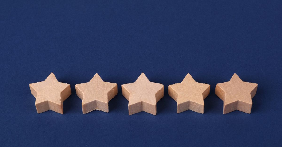 Five wooden stars on a blue background representing a rating system or evaluation concept.