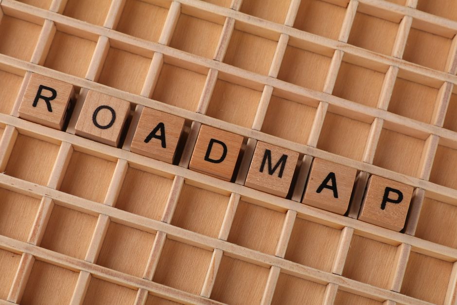 나무 격자 배경 위에 나무 글자 블록으로 'ROADMAP'이라는 단어를 만들었습니다.