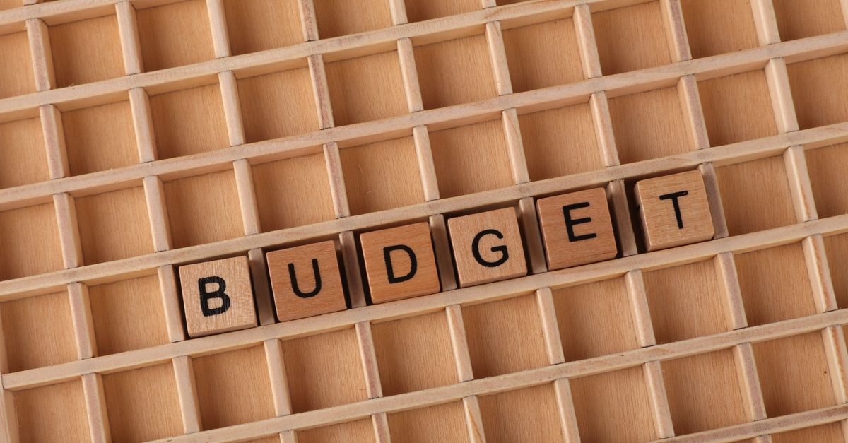 Photo by Ann H Wooden letter tiles spelling 'budget' on a wooden grid background, symbolizing finance and planning.