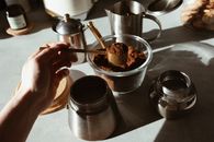 Person Holding Stainless Steel Cup With Brown Powder