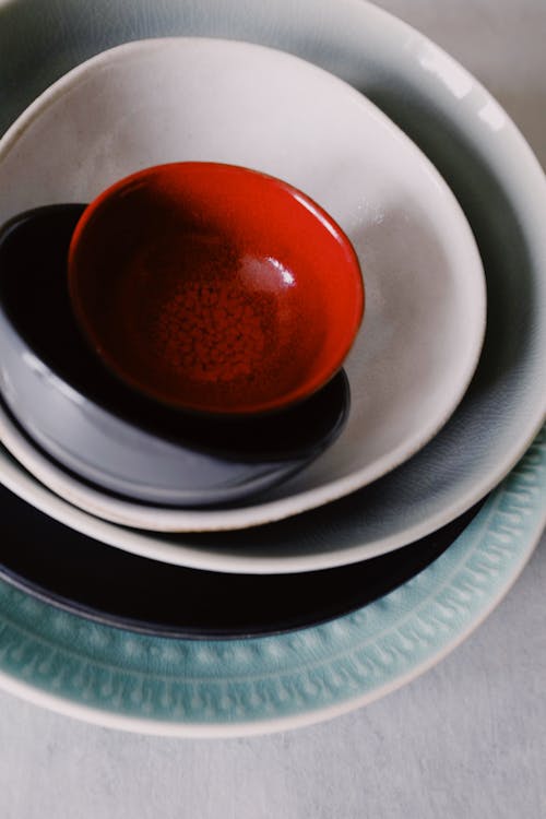 Red Round Ceramic Bowl on White Ceramic Plate