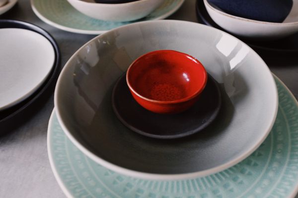 Bowls and plates with one red piece among them