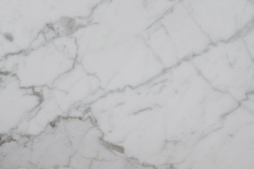 Free Close-up of a smooth white marble surface with natural veining, ideal for backgrounds. Stock Photo