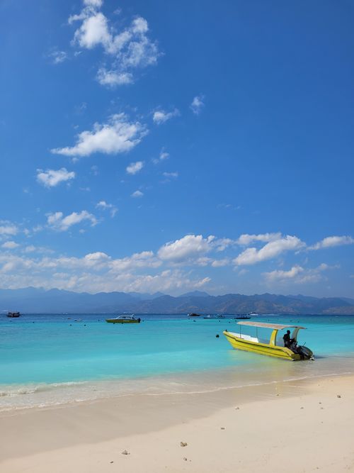 Free Beautiful view of a clear blue sea with boats, under a bright sky in West Nusa Tenggara. Stock Photo