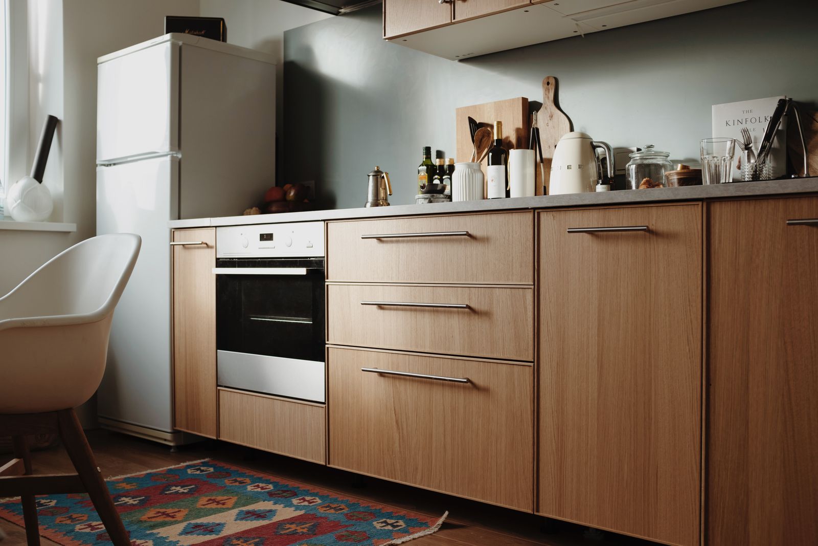 Cuisine moderne avec tiroirs ouverts et casseroliers compartimentés, façades en bois clair, plan de travail dégagé