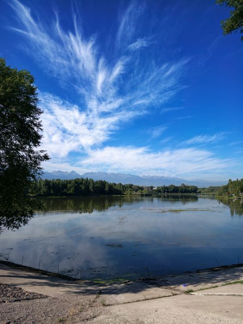 Free Stunning view of a lake with reflections and distant mountains under a vibrant sky in Almaty, Kazakhstan. Stock Photo