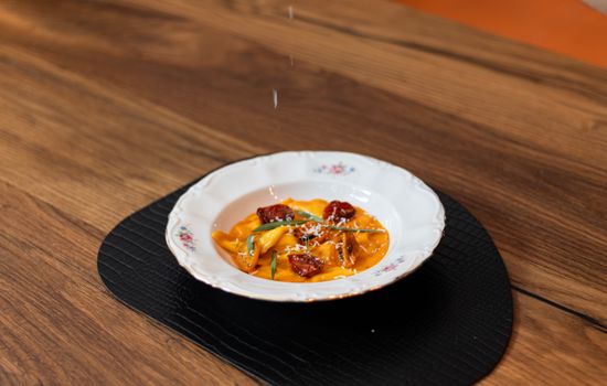 Delicious Italian tagliatelle pasta with tomato sauce served in an elegant dish, shot on a rustic wooden table.