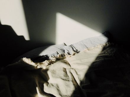 Morning light falling across a made bed — photo by ready made on Pexels