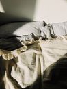 Unmade bed with bedspread and pillows