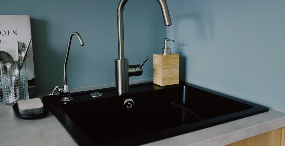 A stainless steel kitchen faucet over a clean sink — the U-bend below is a common American cockroach entry point