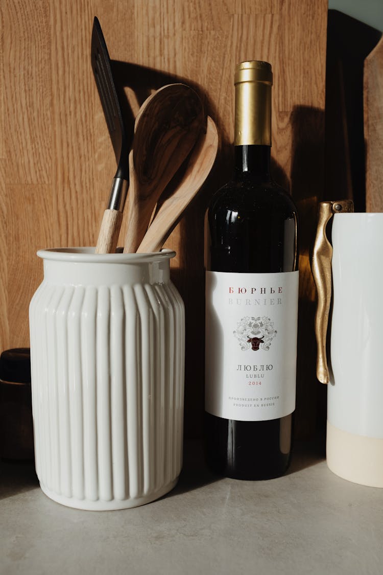 Bottle Of Wine And Tableware On Table In Light Kitchen