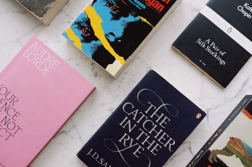 Free Top view of composed famous novels with vivid multicolored covers placed on white marble surface Stock Photo