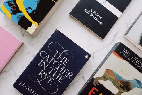 Free From above of arranged classic novels with colorful covers placed on white marble surface Stock Photo