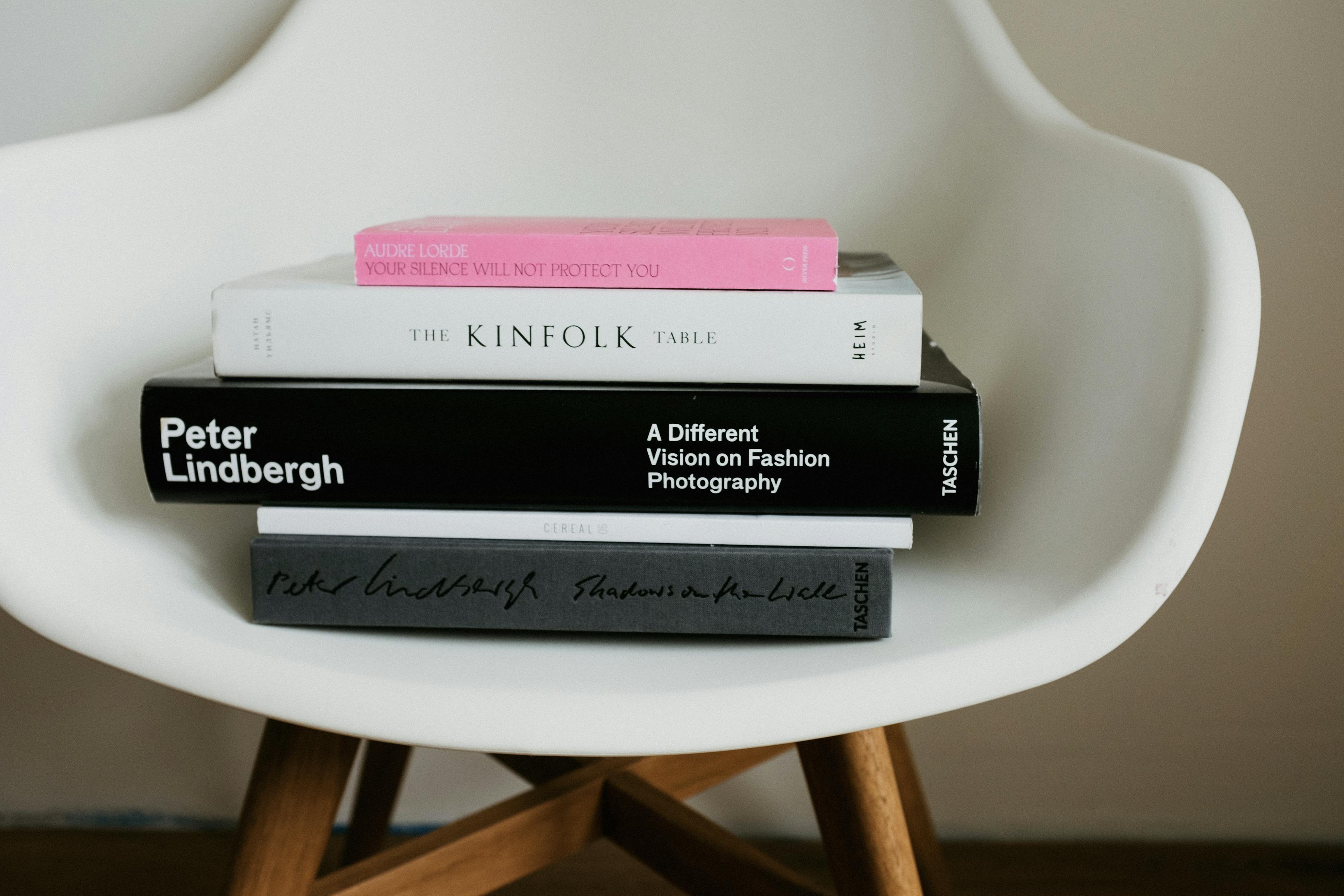 Stack of art books placed on white chair · Free Stock Photo