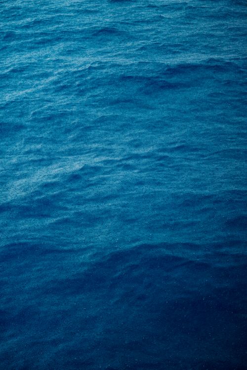 Free A calm and deep blue ocean surface with gentle waves for a natural and tranquil ambiance. Stock Photo