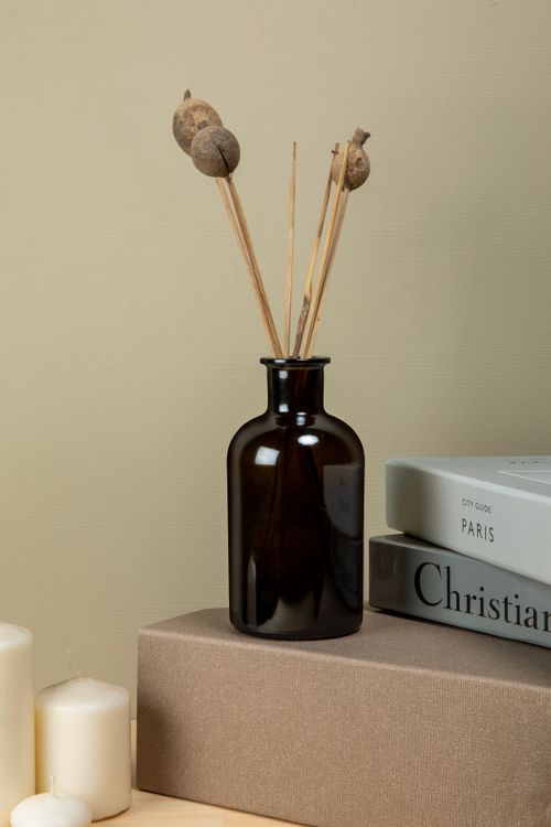 Free Simple and elegant minimalist decor featuring dried flowers in a dark vase on a table with books. Stock Photo