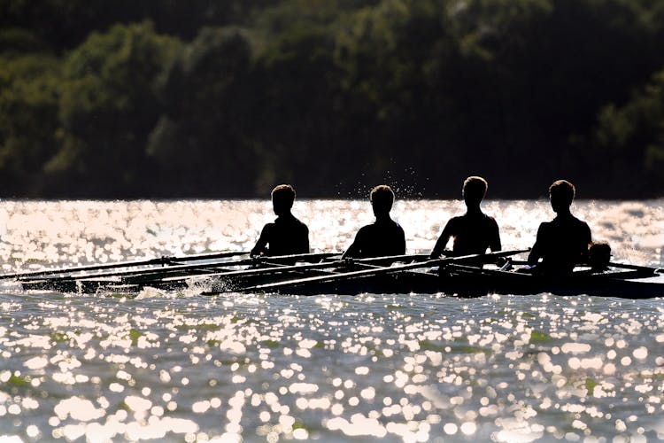 People Rowing In Boat