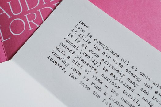 Typewriting text on paper lying over book