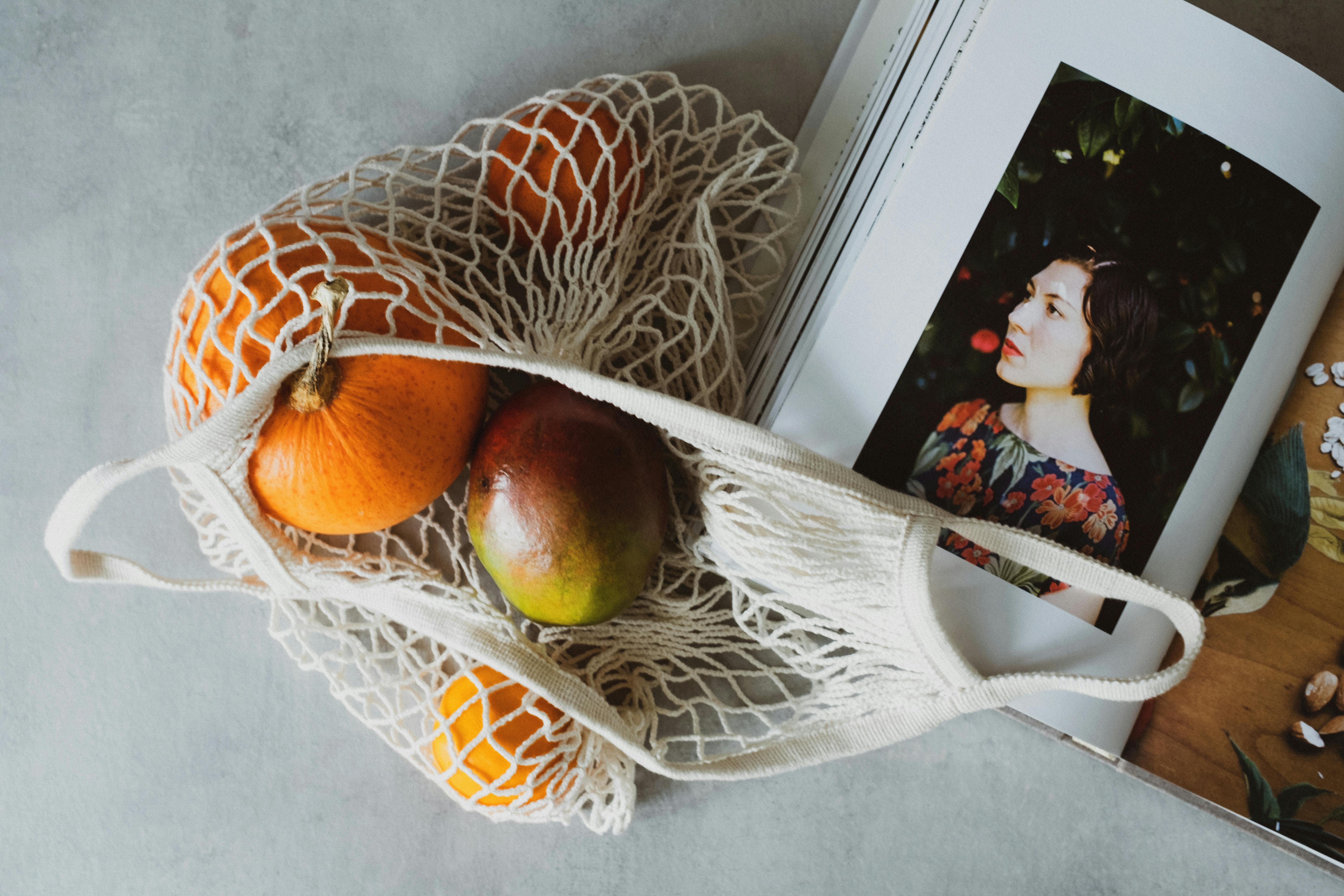 opened cookbook on table together with fruits