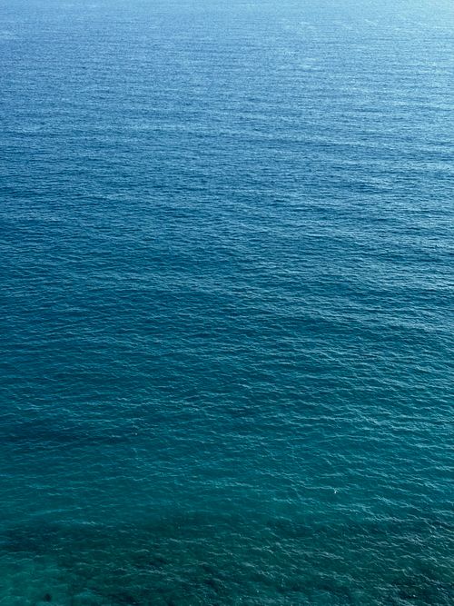 Free Expansive view of calm ocean waters, showcasing rich blue hues and gentle waves. Stock Photo