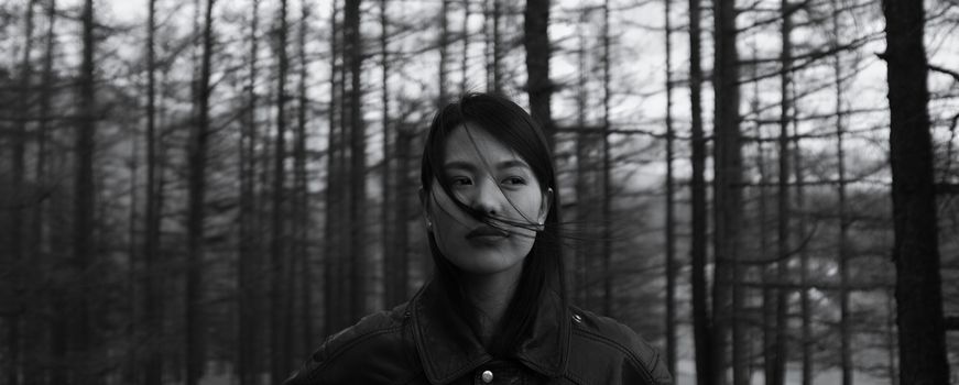 一位体贴的女人站在宁静的森林中，显得平静而孤独