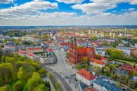 Scenic aerial view of Bialystok, Poland featuring a prominent red brick church and vibrant cityscape.