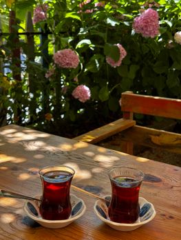 Enjoy a serene moment with Turkish tea amidst blooming hydrangeas.