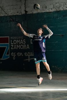 A young athlete prepares to hit a volleyball in an indoor court in Lomas de Zamora.