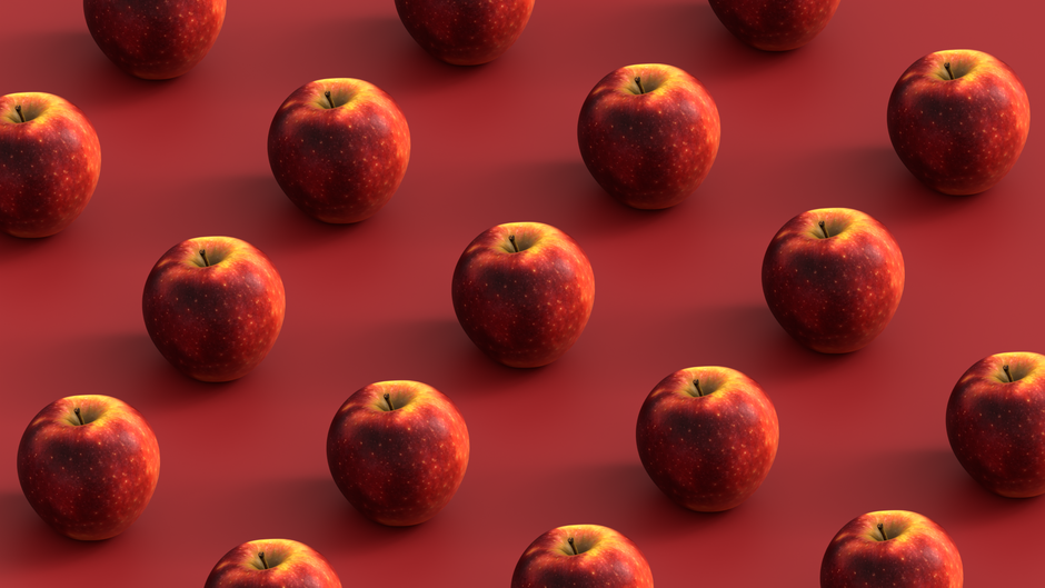 A repeating pattern of fresh red apples arranged geometrically on a red surface.