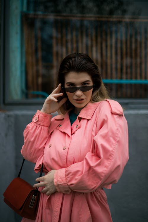 Woman In Pink Coat Wearing Black Framed Sunglasses