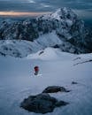 日出时分，在斯洛文尼亚，一位孤独的登山者徒步攀登着白雪皑皑的山峰