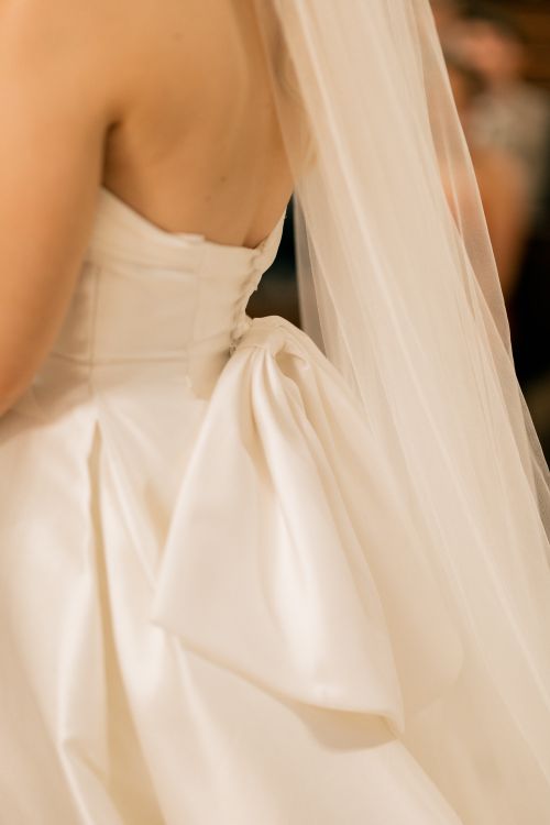 Free Close-up of an elegant white wedding dress with a satin bow and veil, ideal for bridal fashion. Stock Photo
