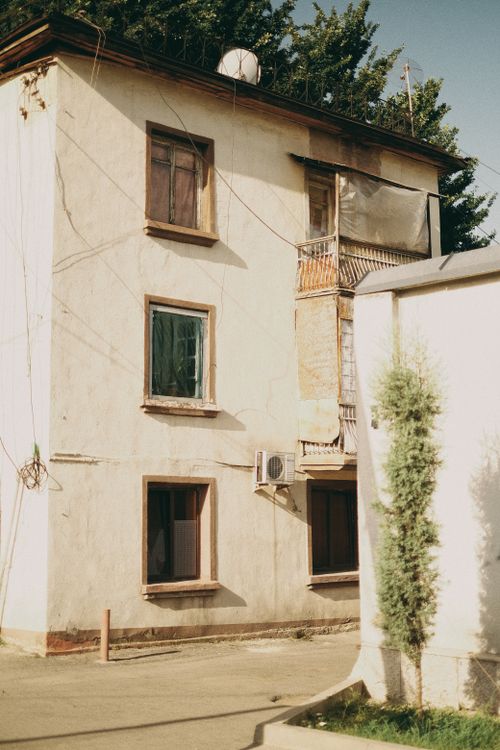 Free Charming multi-story building in Dushanbe, displaying rustic architecture and warm sunlight. Stock Photo
