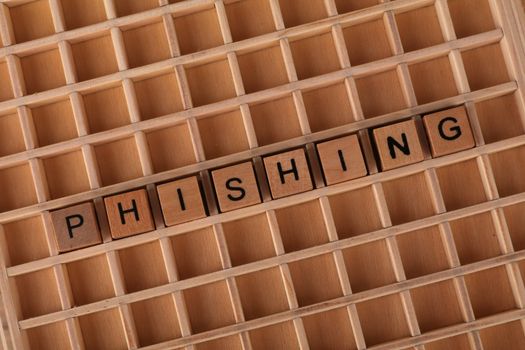 Wooden Scrabble tiles arranged to spell 'Phishing', illustrating online security concepts.