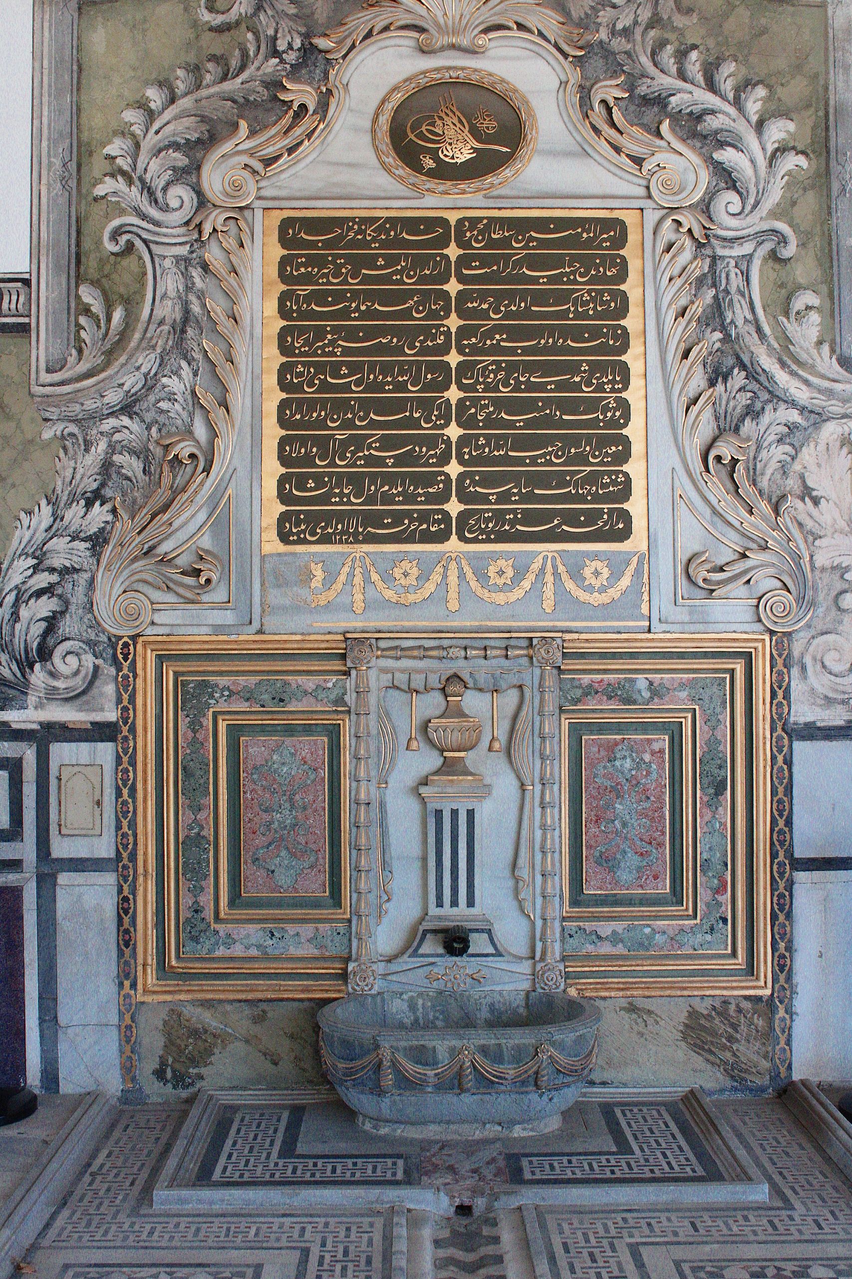 A beautifully detailed historic fountain featuring Arabic calligraphy and ornate design.